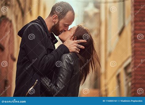 Bearded Man And Brunette Girl Kissing On The Background Of The Old European Street Stock Image
