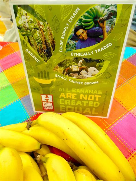 A Bunch Of Bananas Sitting On Top Of A Colorful Table Cloth Next To A Book