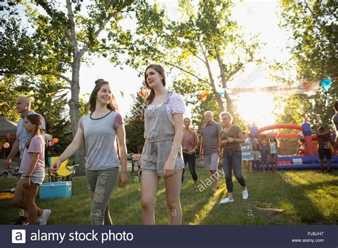 Teenage Girls Arriving At Summer Neighborhood Block Party In Park Stock