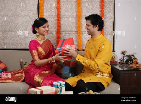 indian husband surprising wife with a t on diwali anniversary birthday while sitting on