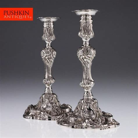 Two Silver Candlesticks Sitting Next To Each Other
