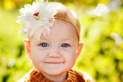 A Large Portrait Of A Pretty Baby Girl With A Flower On Her Head