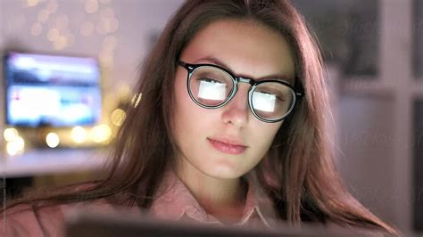 woman with glasses eyes looking at the monitor surfing the internet extreme close up with