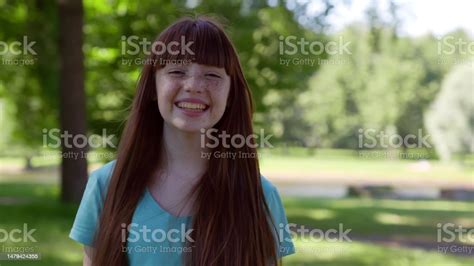 Medium Shot Of Cheerful Preteen Girl Looking At Camera Outdoors Stock