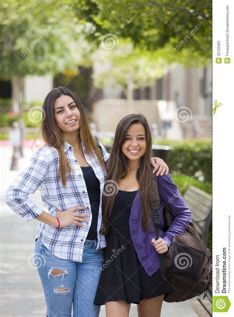 Mixed Race Female Couple Carrying Backpacks On School