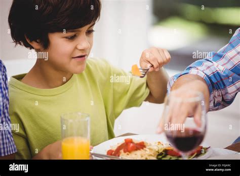 Boy Having A Meal At Dining Table Stock Photo Alamy
