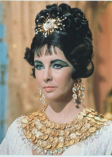 A Woman With Black Hair And Gold Jewelry On Her Face Wearing An Elaborate Necklace