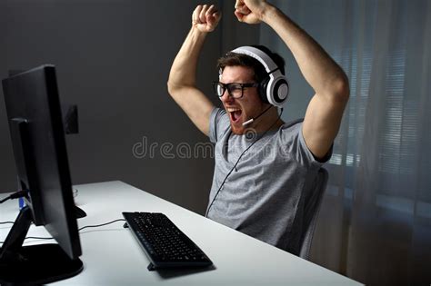 Man In Headset Playing Computer Video Game At Home Stock