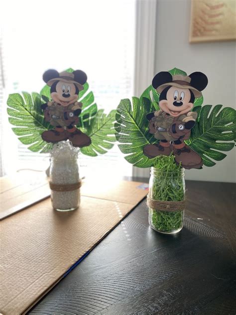 Two Vases Filled With Plants And Mickey Mouse Cut Outs On Top Of A Table