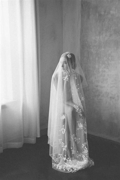 Black And White Photograph Of A Woman In A Wedding Dress With Her Veil Over Her Head