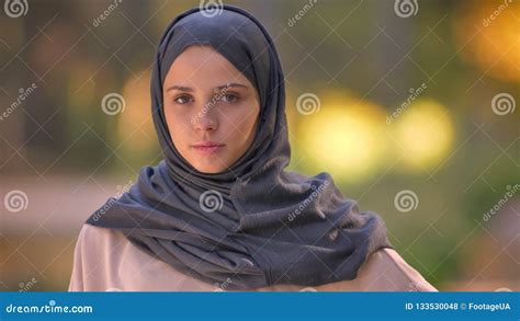 close up portrait of muslim girl in hijab watching into camera slowly waving her head stock