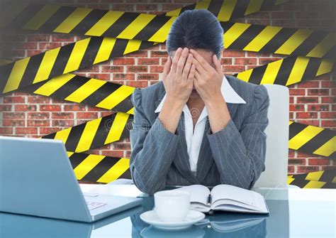 Tensed Businesswoman Sitting With Hand On Forehead Against Brick Wall