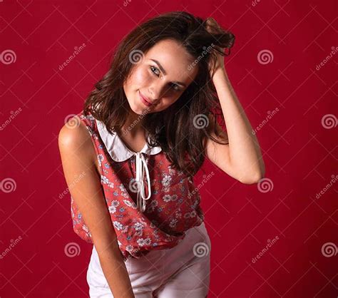 Portrait Of A Stunning Young Brunette Girl On A Red Background A