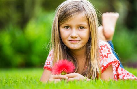 menina de sorriso que encontra se na grama verde com flores foto de stock imagem de olhos