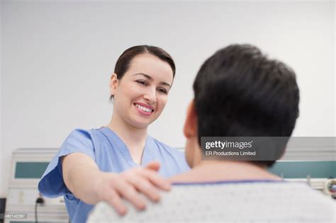 Hispanic Nurse Talking To Patient In Hospital High Res Stock Photo