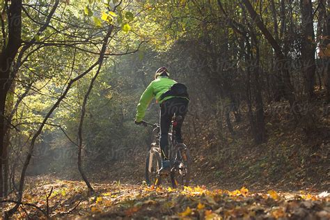 Riding A Mountain Bike Down A Forest Trail By Stocksy Contributor