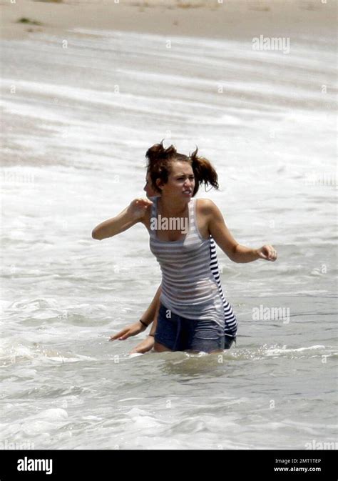 miley cyrus frolics in the surf with friends castmates while filming her latest hannah montana