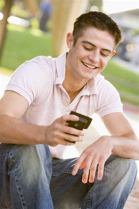 Teenage Boy Sitting Outdoors Using Mobile Phone Stock Image Image Of