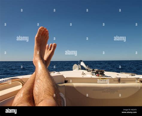 put your feet up a pair of feet on the front of a boat with a blue sky behind on the