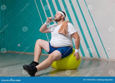 Overweight Man Is Sitting On A Fitness Ball Exhausted After A Hard