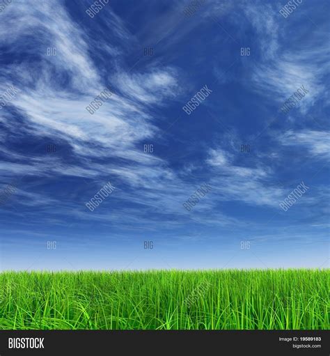 High Resolution Green Grass Over A Blue Sky Background Stock Photo