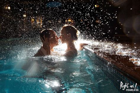 Two People In A Swimming Pool With Water Splashing All Over The Face