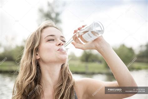 Young Woman Drinking Water From Bottle Outdoors — Carefree Female