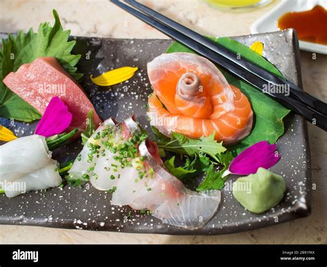 Japanese Raw Fish On Black Plate Also Known As Sashimi Stock Photo Alamy