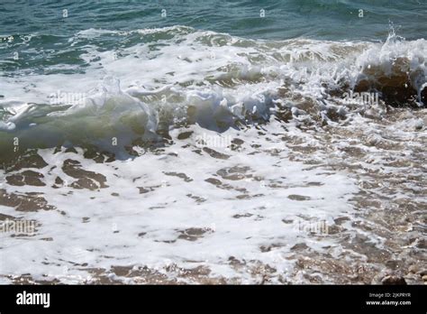 The Foam Waves Hitting A Sandy Seashore Of A Beach Stock Photo Alamy