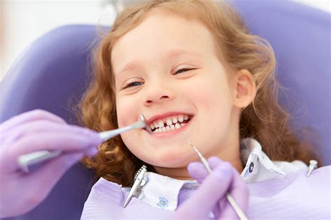Pediatric Dentist Making Examination Procedure For Smiling Cute Little