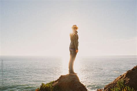Woman Standing On Rock In Nature Looking Out At Ocean By Trinette Reed