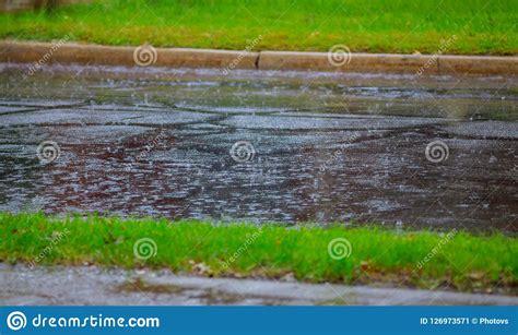 Raindrops On Asphalt Road With Water Ripples During Heavy Rain Stock