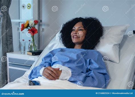 Smiling African American Female Patient Lying In A Hospital Bed Stock