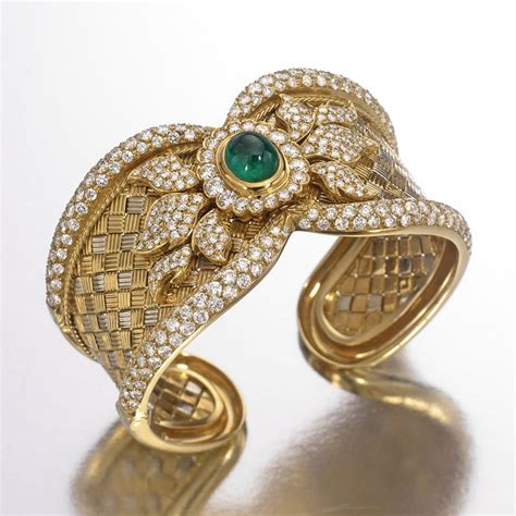 an 18 karat gold diamond and emerald cuff bracelet the hinged cuff set in the center with a