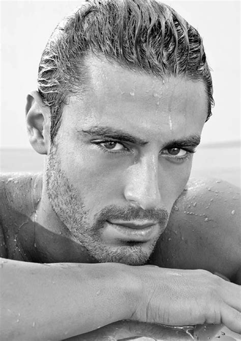 A Man With Wet Hair And No Shirt On Laying In The Water Looking At The Camera