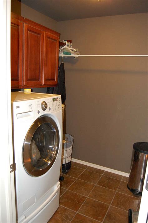 Separate Inside Laundry With Cabinetry And Bar For Hanging Clothes