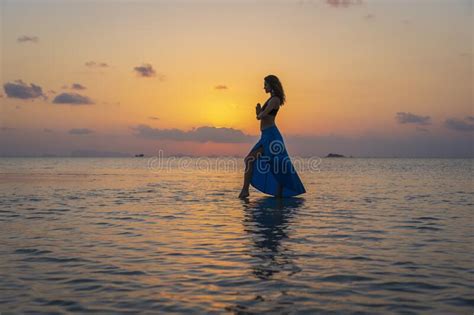 Young Beauty Girl Dancing At Tropical Beach On Sea Water At Paradise Island At Sunset Summer