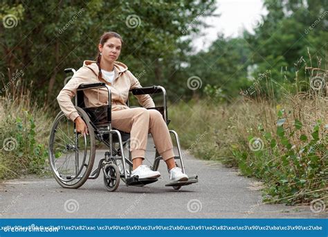 A Young Disabled Girl Sits In A Wheelchair On The Street The Concept