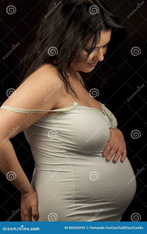 Beautiful Pregnant Brunette In Light Clothes Showing Signs Of Pr Stock