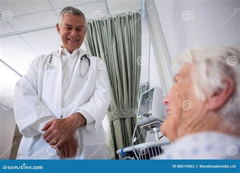 Doctor Interacting With Senior Patient In Ward Stock Photo Image Of