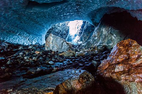 The Inside Of An Ice Cave With Rocks And Water Coming Out From Its