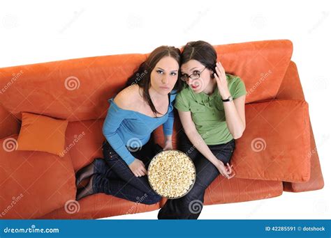 Female Friends Eating Popcorn And Watching Tv At Home Stock Image