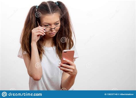 Young Serious Cute Girl Holding The Cellphone And Looking For The Wi Fi