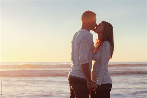 Young Couple Kissing On The Beach At Sunset On Vacation By Stocksy Contributor Paff Stocksy