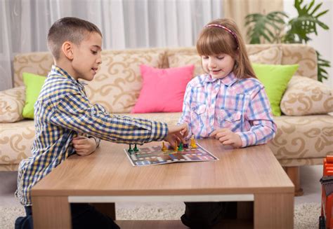 Children Playing Board Game Ludo At Home On The Table Stock Image