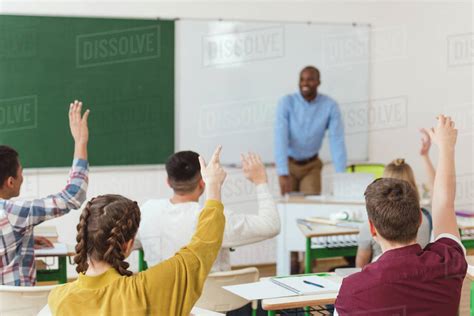 Rear View Of High School Students With Arms Up And African American