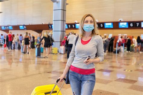 Woman Passenger In Medical Protective Mask At Airport With Luggage