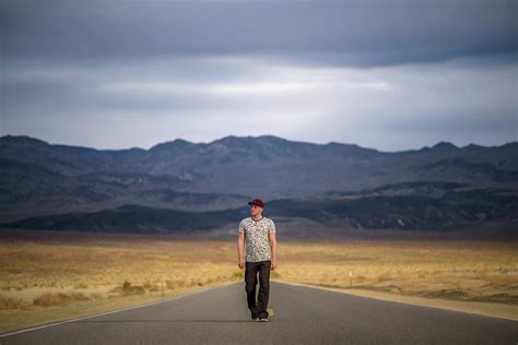 Young Man Walking Alone Through An Empty Street In The Desert Of Death