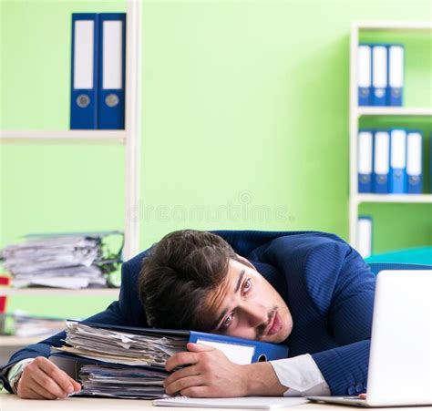 The Businessman Unhappy With Excessive Work Sitting In The Office Stock