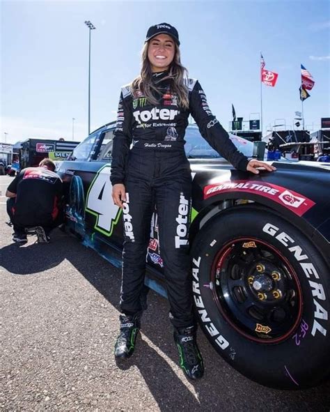 A Woman Standing Next To A Racing Car
